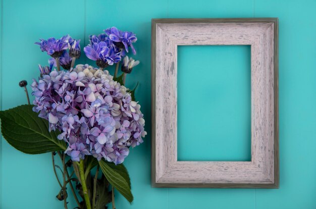 Bovenaanzicht van verse prachtige bloemen zoals daisy en gardenzia op een blauwe achtergrond met kopie ruimte