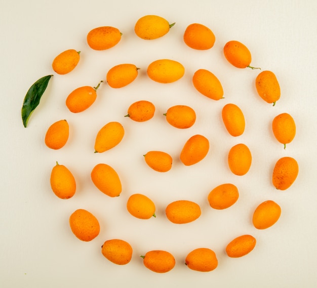 Bovenaanzicht van verse rijpe kumquat vruchten op wit wordt geïsoleerd