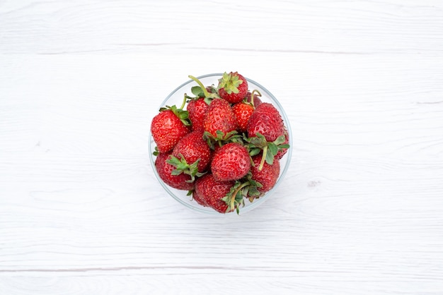 Gratis foto bovenaanzicht van verse rode aardbeien in transparante plaat op licht wit, vers fruit