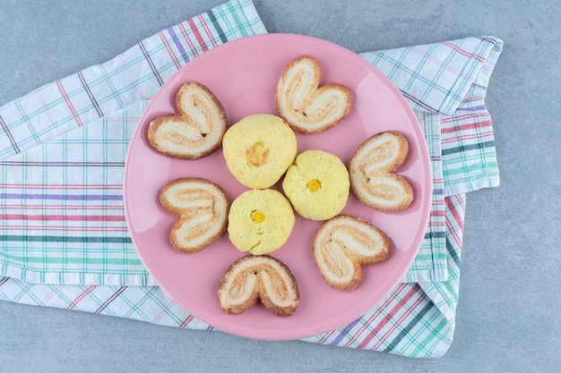 Bovenaanzicht van verse zelfgemaakte koekjes op roze plaat.