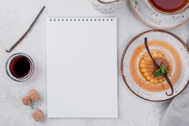 Bovenaanzicht van vla op plaat met munt en notebook