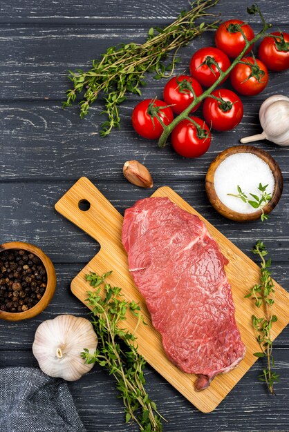 Bovenaanzicht van vlees met tomaten en kruiden