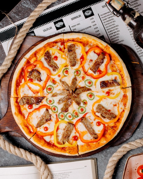 Bovenaanzicht van vlees pizza met kleurrijke paprika