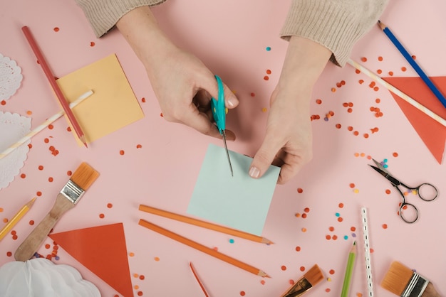 Bovenaanzicht van vrouw blauw papier snijden