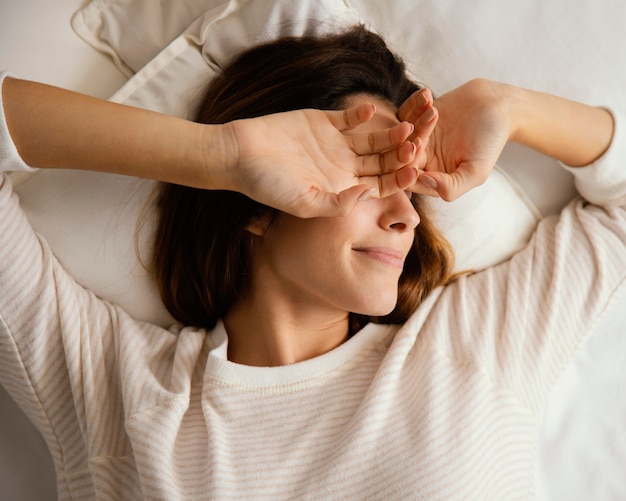 Bovenaanzicht van vrouw in bed thuis wakker