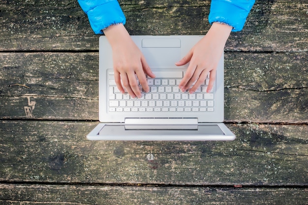 Gratis foto bovenaanzicht van vrouw met behulp van haar laptop op het park.