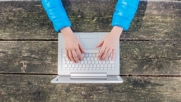 Gratis foto bovenaanzicht van vrouw met behulp van haar laptop op het park.