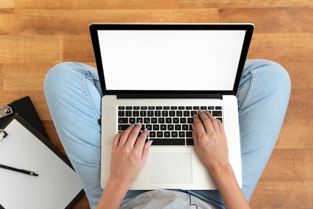 Bovenaanzicht van vrouw thuis werken tijdens quarantaine met laptop
