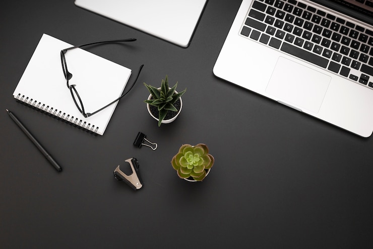 Gratis Foto bovenaanzicht van werkruimte met laptop en vetplanten