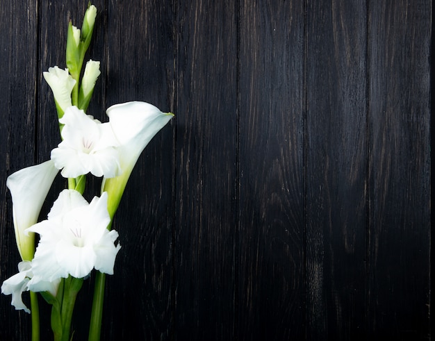 Bovenaanzicht van witte kleur gladiolen en calla lelie bloemen geïsoleerd op zwarte achtergrond met kopie ruimte