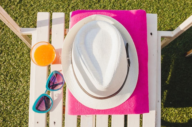 Gratis foto bovenaanzicht van witte stoel met handdoek, hoed en zonnebril