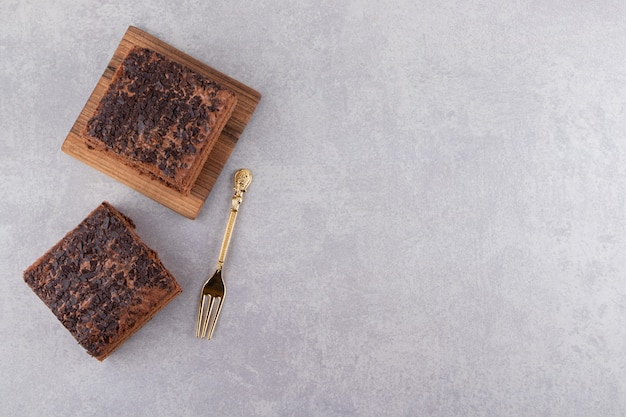 Bovenaanzicht van zelfgemaakte chocolade op houten bord over grijs oppervlak