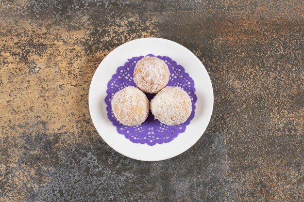 Bovenaanzicht van zelfgemaakte koekjes op plaat over rustieke tafel.