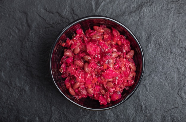 Bovenaanzicht van zelfgemaakte vinaigrette met bonen in zwarte kom.