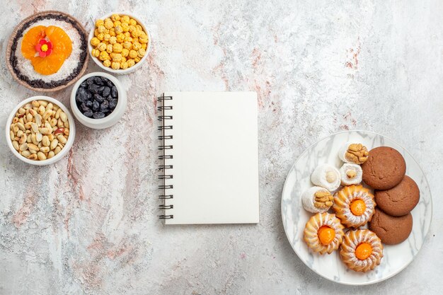 Bovenaanzicht van zoete koekjes met noten en dessert op wit