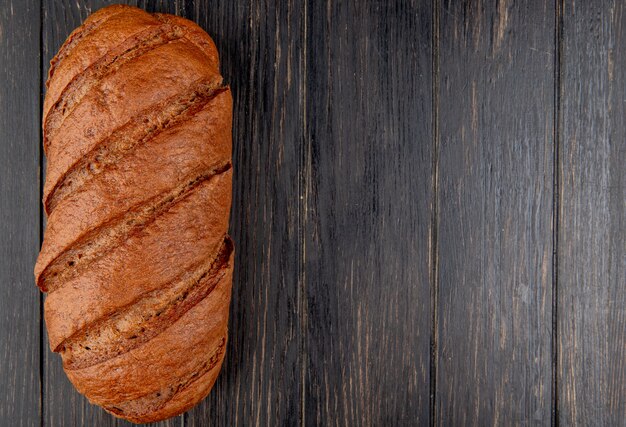 Bovenaanzicht van zwart brood op houten achtergrond met kopie ruimte