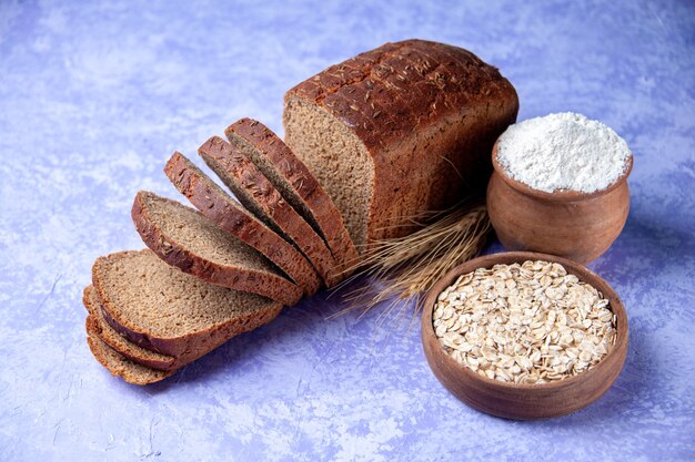 Bovenaanzicht van zwart brood sneetjes meel havermout op licht ijsblauw patroon achtergrond met vrije ruimte