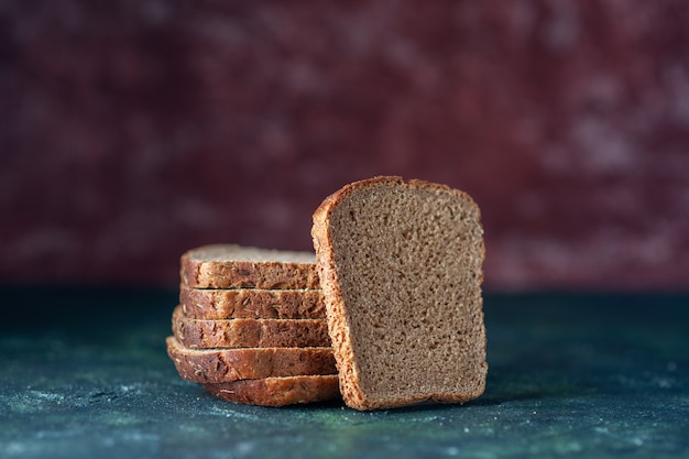 Bovenaanzicht van zwarte sneetjes brood op gemengde kleuren achtergrond met vrije ruimte
