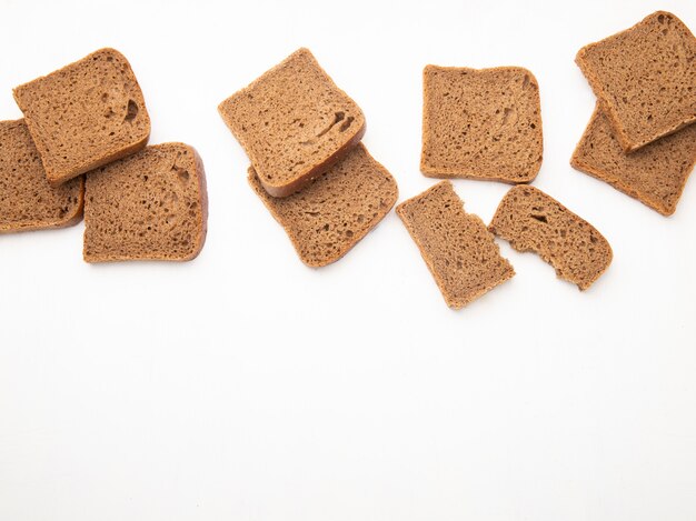 Bovenaanzicht van zwarte sneetjes brood op witte achtergrond met kopie ruimte