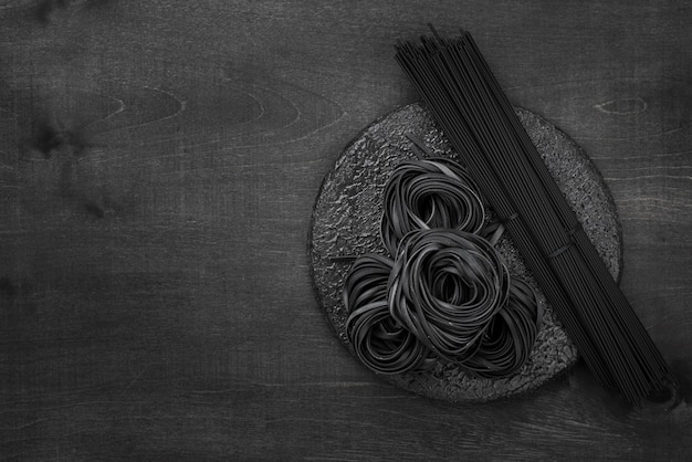 Bovenaanzicht van zwarte tagliatelle en spaghetti met kopie ruimte