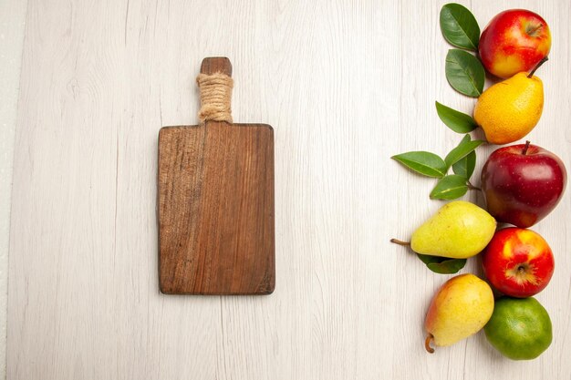 Bovenaanzicht vers fruit appels en peren op wit bureau fruit rijpe boom kleur zacht veel vers