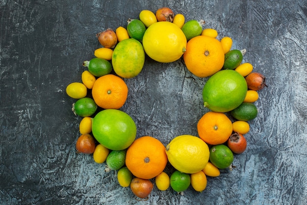 Bovenaanzicht vers fruit samenstelling citroenen feijoa en mandarijnen op grijze achtergrond