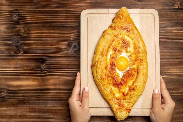 Bovenaanzicht vers gebakken brood met gekookt ei op houten oppervlak brood deeg maaltijd broodje eten ontbijt ei