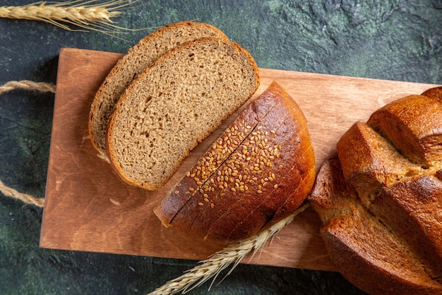 Bovenaanzicht vers gesneden brood op donker bureau