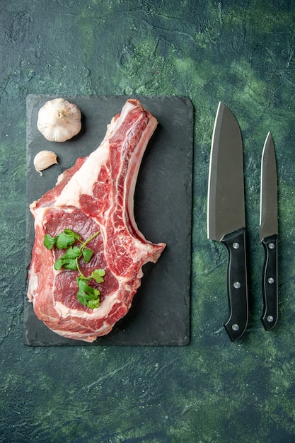 Bovenaanzicht vers vlees plak met messen op donkerblauwe achtergrond keuken koe eten slager vlees kip kleur