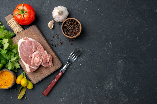 Bovenaanzicht vers vlees plak rauw vlees met greens op donkere barbecue schotel peper keuken eten koe salade diermeel voedsel