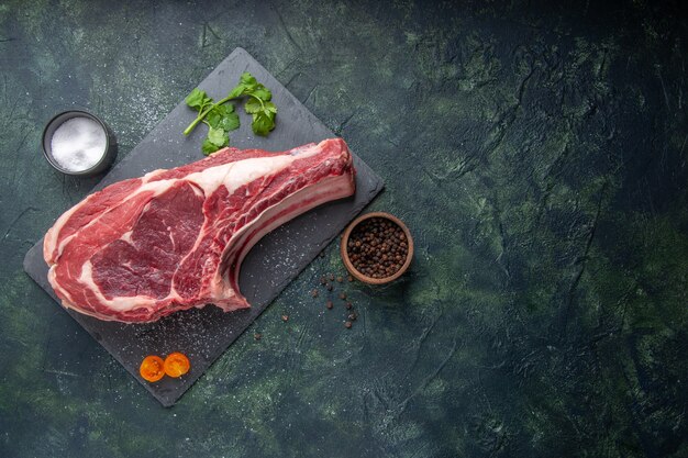 Bovenaanzicht vers vlees plak rauw vlees met peper en groen op donkere achtergrond kippenmeel dier foto barbecue voedsel slager