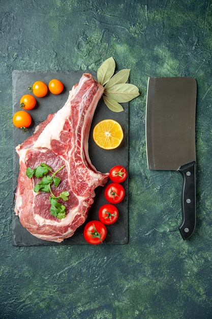 Bovenaanzicht vers vleesplakje met tomaten op donkerblauwe achtergrond voedsel vlees keuken dier koe slager kip kleuren