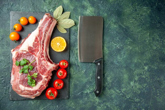 Bovenaanzicht vers vleesplakje met tomaten op donkerblauwe achtergrond voedsel vlees keuken dier slager kip kleur koe