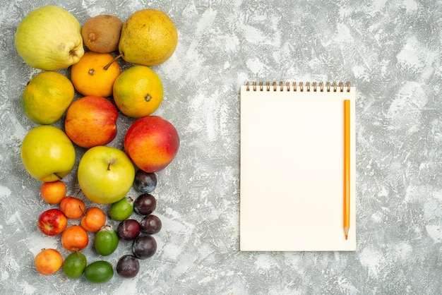 Gratis foto bovenaanzicht verschillende fruitsamenstelling vers fruit op witte achtergrond boom vitamine verse kleuren fruit rijp