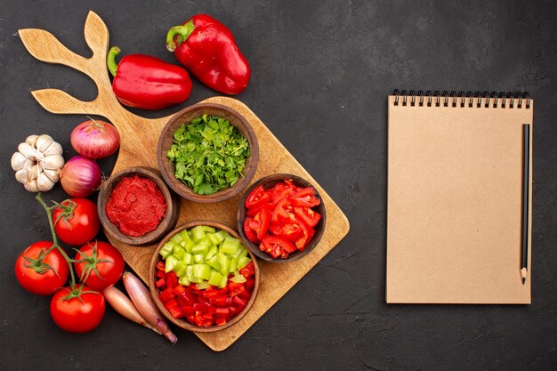 Bovenaanzicht verschillende groenten met greens op grijze achtergrond salade maaltijd gezondheid rijp pittig