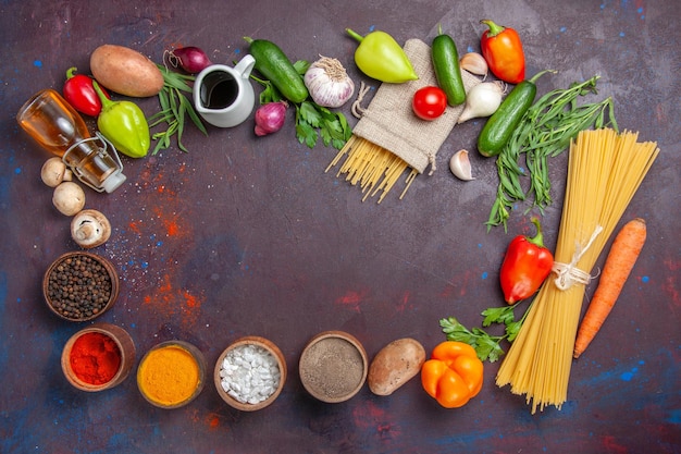 Bovenaanzicht verschillende ingrediënten rauwe pasta verse groenten en kruiden op donkere oppervlakte product verse maaltijd salade gezondheidsdieet