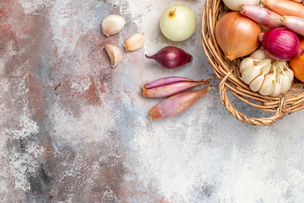 Bovenaanzicht verschillende ingrediënten uien en knoflook in de mand