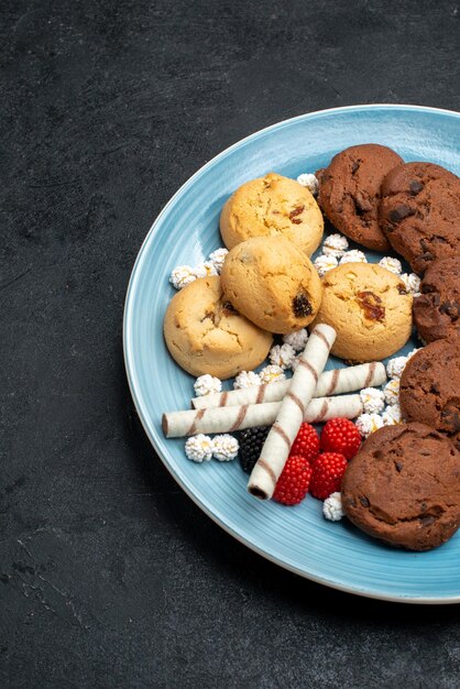 Bovenaanzicht verschillende koekjes zoete en heerlijke koekjes binnen op het grijze oppervlak