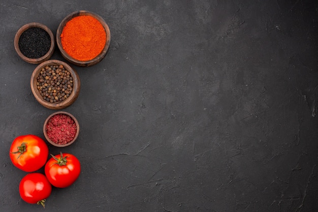 Bovenaanzicht verschillende kruiden met tomaten op grijze achtergrond pittige peper kleur vers