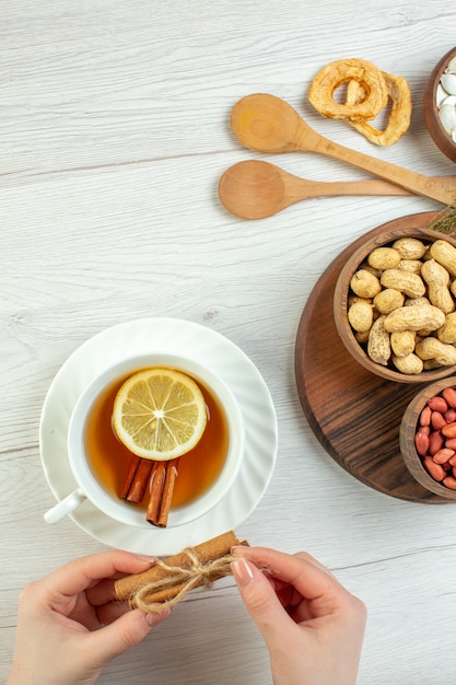 Bovenaanzicht verschillende noten pinda's hazelnoten en walnoten met kopje thee op witte tafel