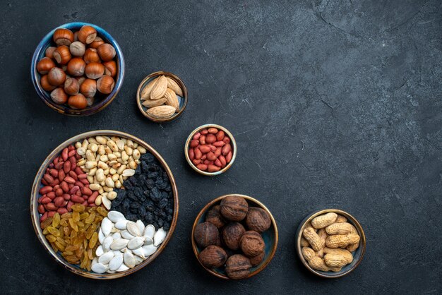 Bovenaanzicht verschillende noten samenstelling van snacks op donkergrijze achtergrond noten snack foto walnoot hazelnoot