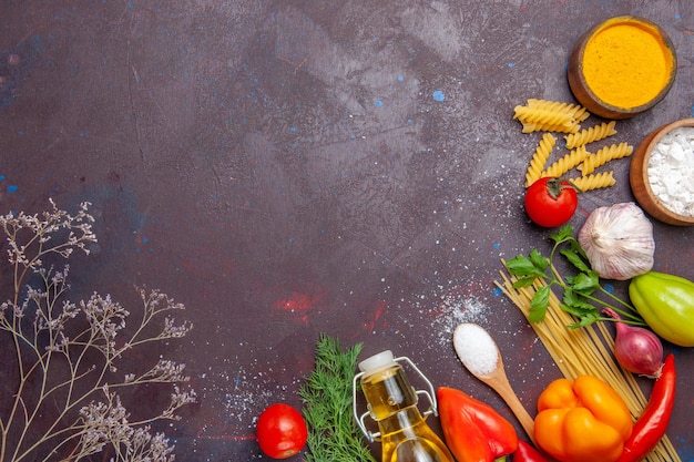 Gratis foto bovenaanzicht verschillende producten rauwe pasta verschillende kruiden en groenten op donkere achtergrond gezondheidsdieet rauw voedsel