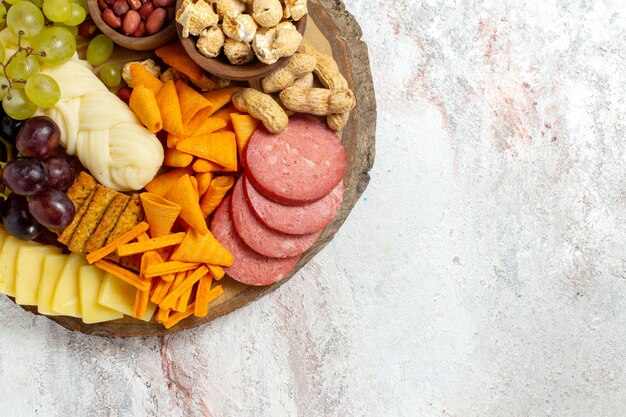 Bovenaanzicht verschillende snacks noten cips kaas en worst op witte achtergrond moer snack maaltijd eten