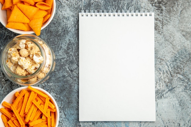 Bovenaanzicht verschillende snacks popcorn beschuit en cips op lichte ondergrond