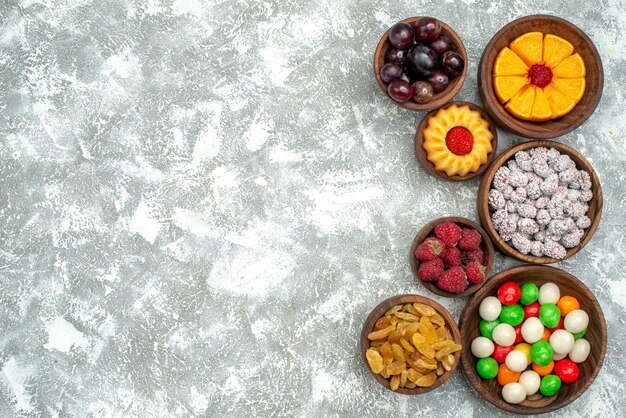 Bovenaanzicht verschillende snoepjes met rozijnen en fruit op witte achtergrond fruitcake kandijsuiker