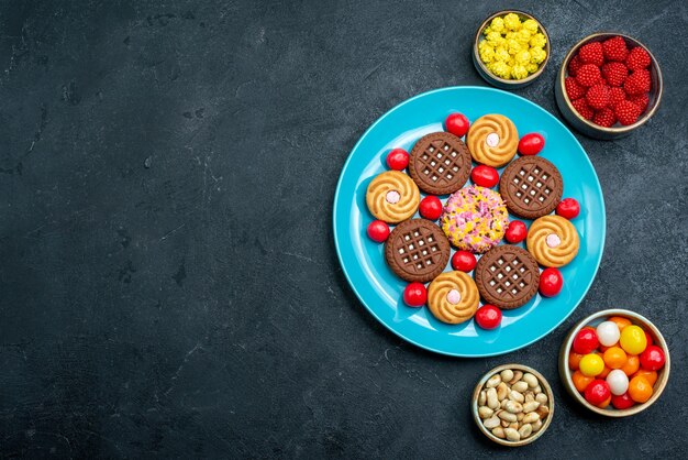 Bovenaanzicht verschillende suikerkoekjes met snoepjes in plaat op grijze ondergrond snoep zoete thee koekjes koekjessuiker