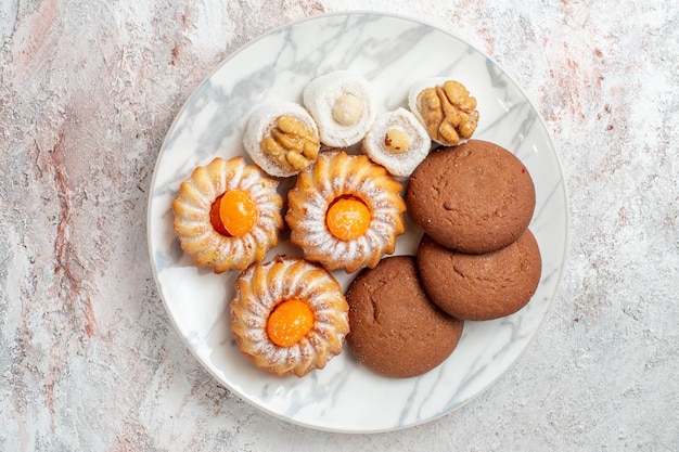 Bovenaanzicht verschillende taarten kleine snoepjes op witte achtergrond cookies biscuit suiker thee zoete cake