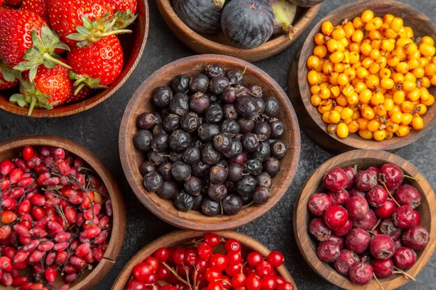 Bovenaanzicht verschillende vers fruit binnen platen op donkere achtergrond