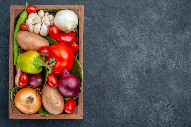 Bovenaanzicht verschillende verse groenten op de donkere tafel kleur groente verse salade rijp