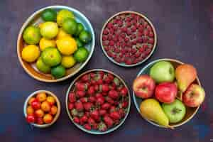 Gratis foto bovenaanzicht verschillende vruchten bessen en citrusvruchten op donkere bureau citrus tropisch exotisch oranje fruit